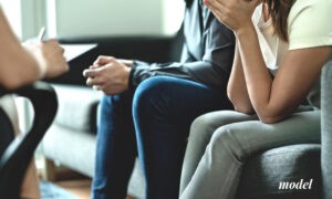 Two People Sitting on Couch In Grief After News of Loved One